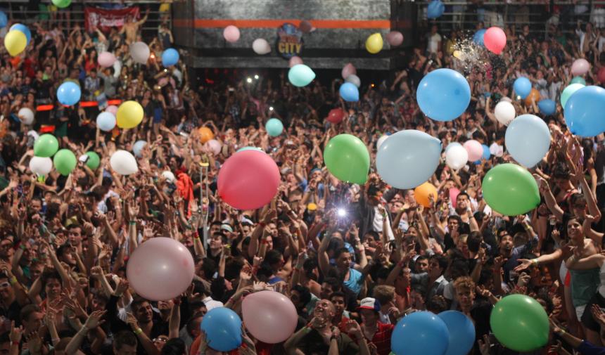 A crowd of students has balloons dropped on them during their grad tip to Cancun